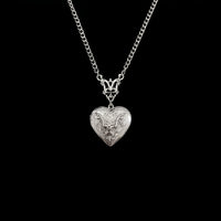 Ornate bat heart locket hanging on pure black background