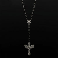 Black bead rosary with silver cross hanging on pure black background