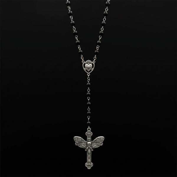 Black bead rosary with silver cross hanging on pure black background